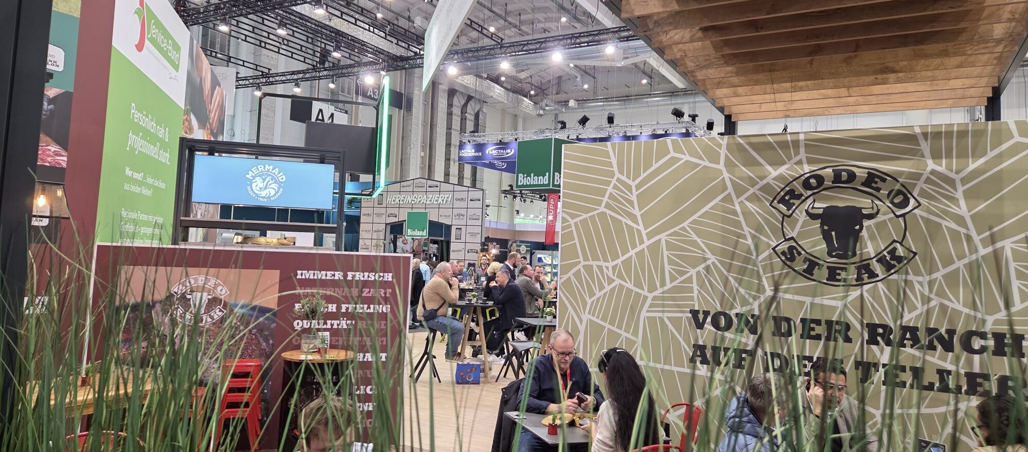 Eine Gruppe von Menschen sitzt an Tischen in einem großen Raum.