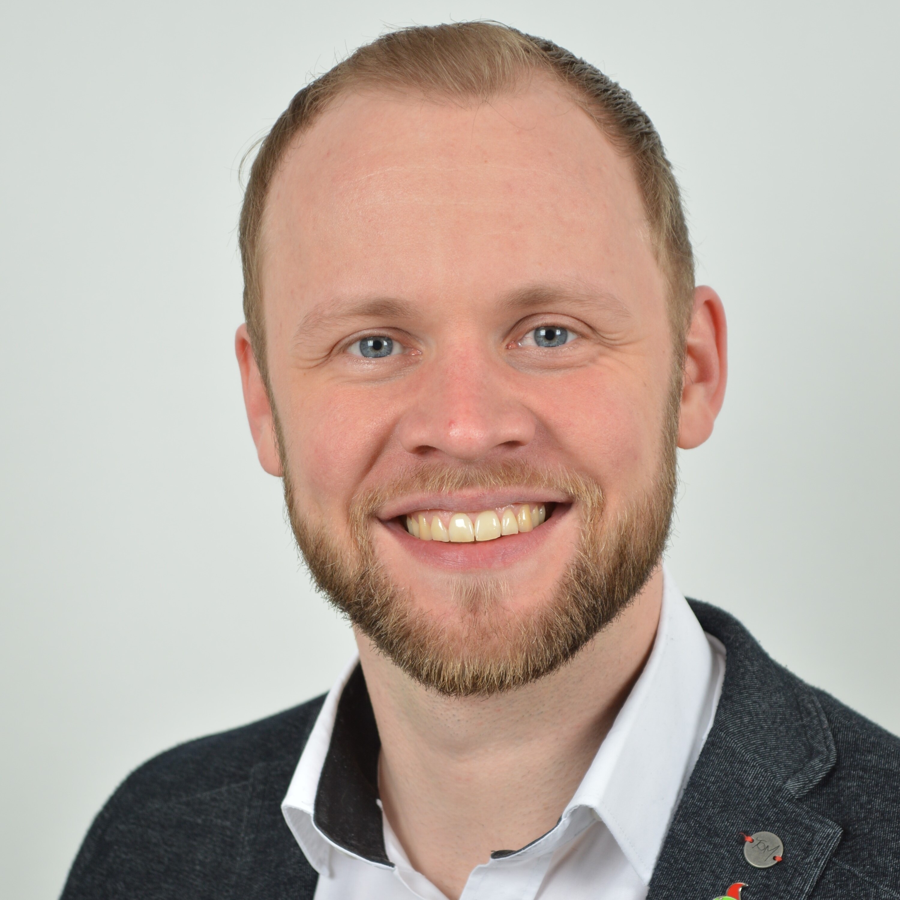 Ein Mann lächelt in die Kamera.