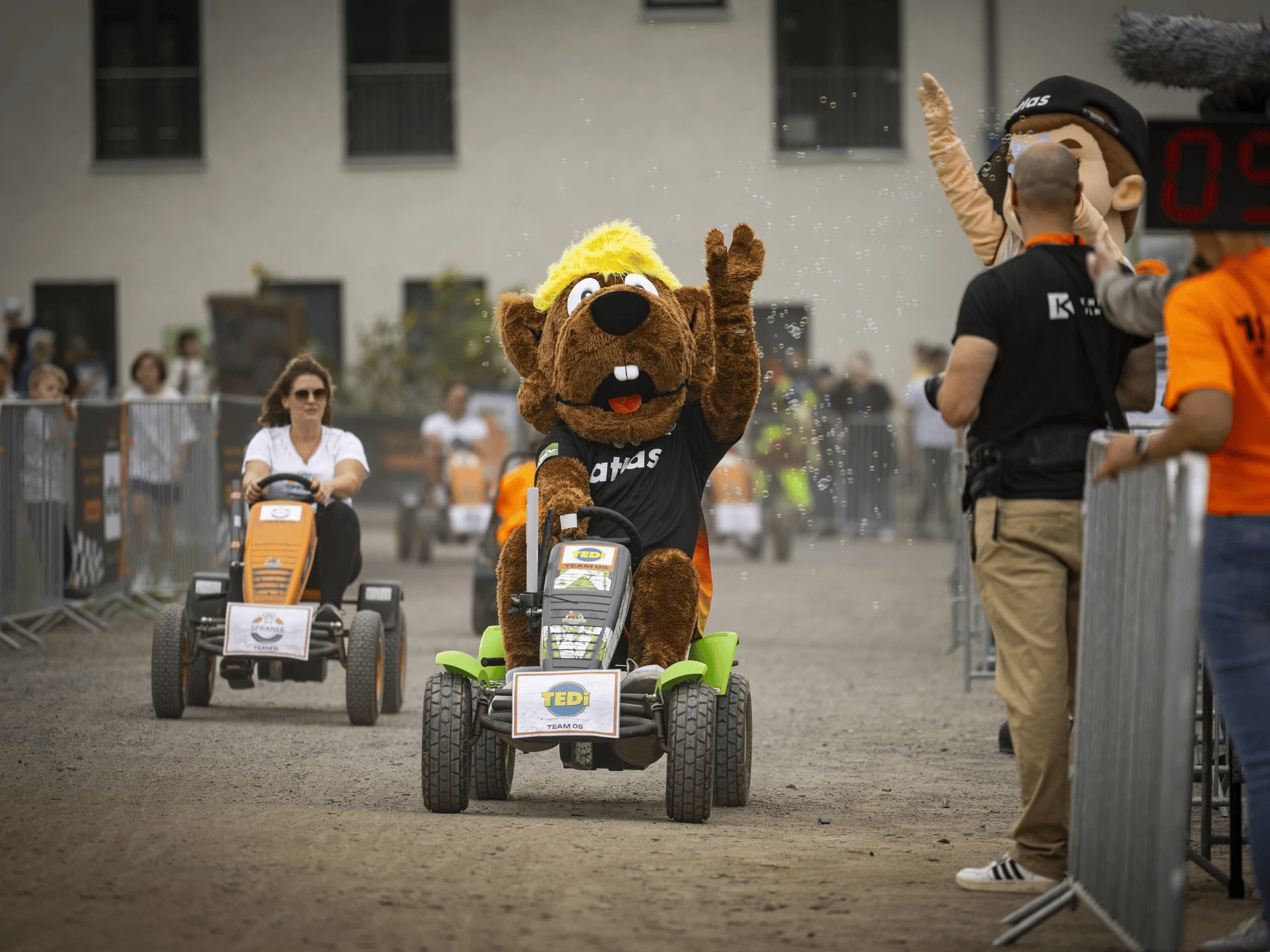 Haniball beim GoKart Rennen Eine Person in Kleidung fährt auf einem Rasenmäher.