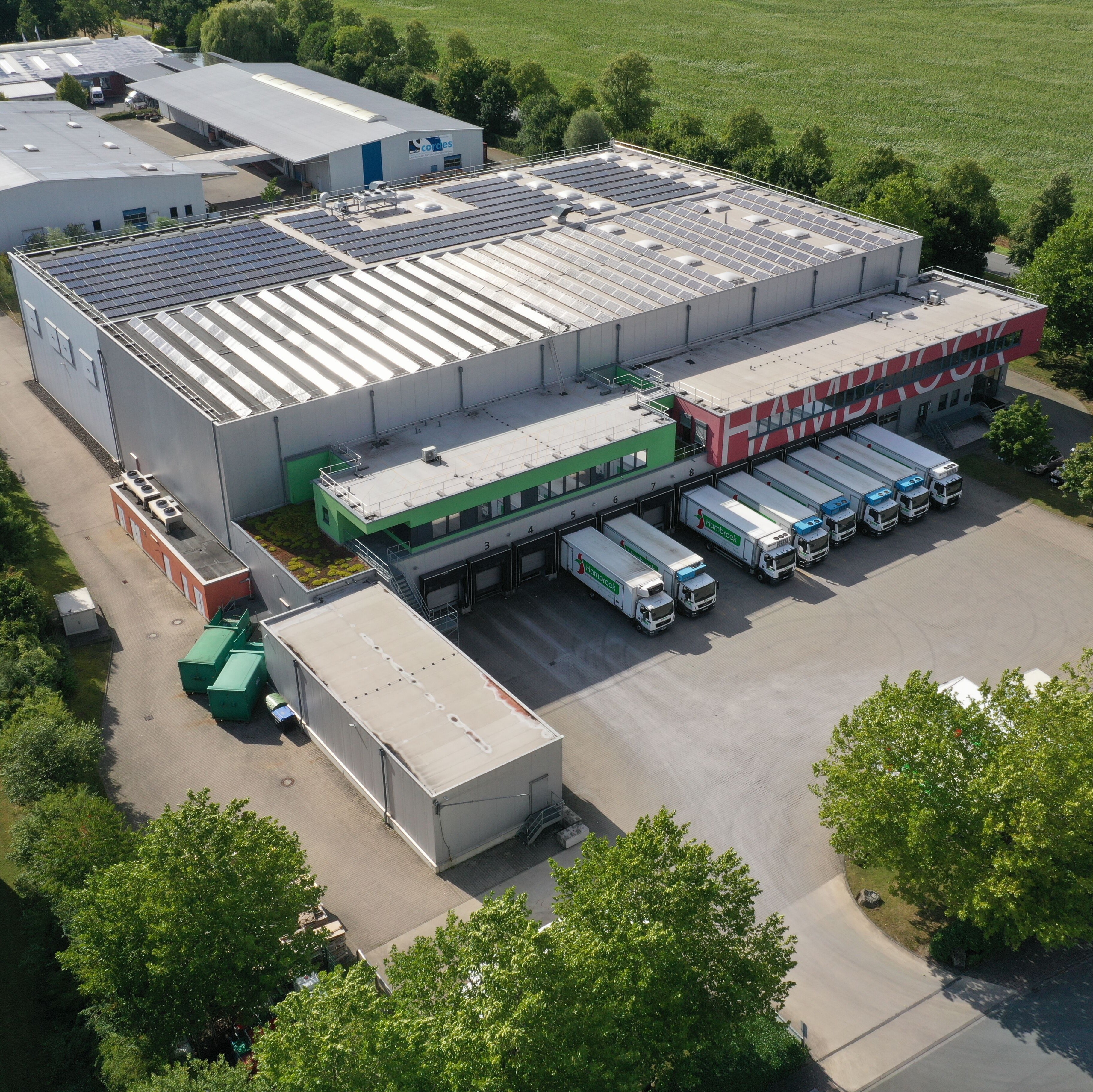 test Großes Lagerhaus mit davor geparkten Lastwagen.