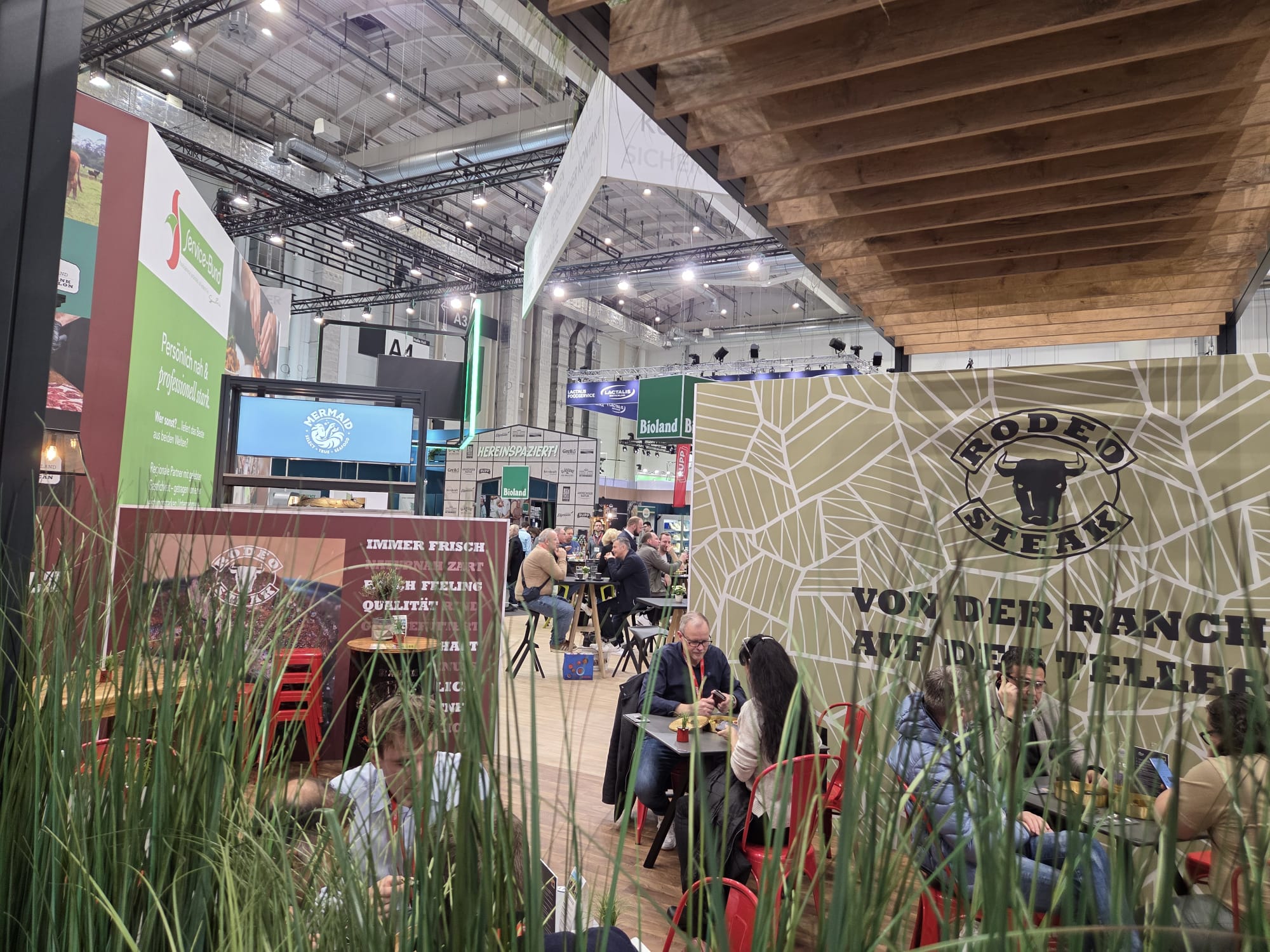 Eine Gruppe von Menschen sitzt an Tischen in einem großen Raum.