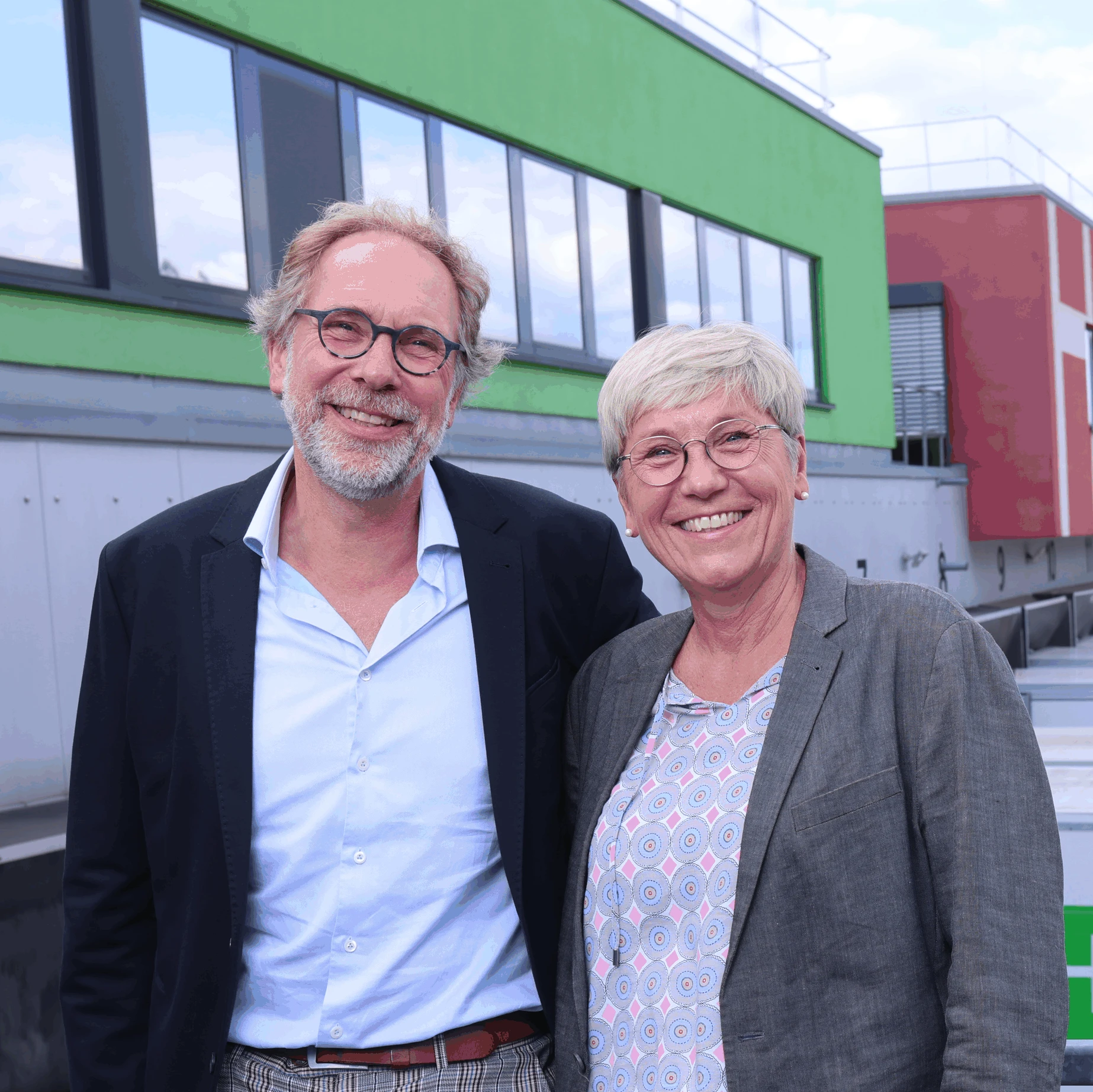Inhaber Frau Niemann und Herr Hambrock stehen leger gekleidet auf dem Hof des Unternehmens